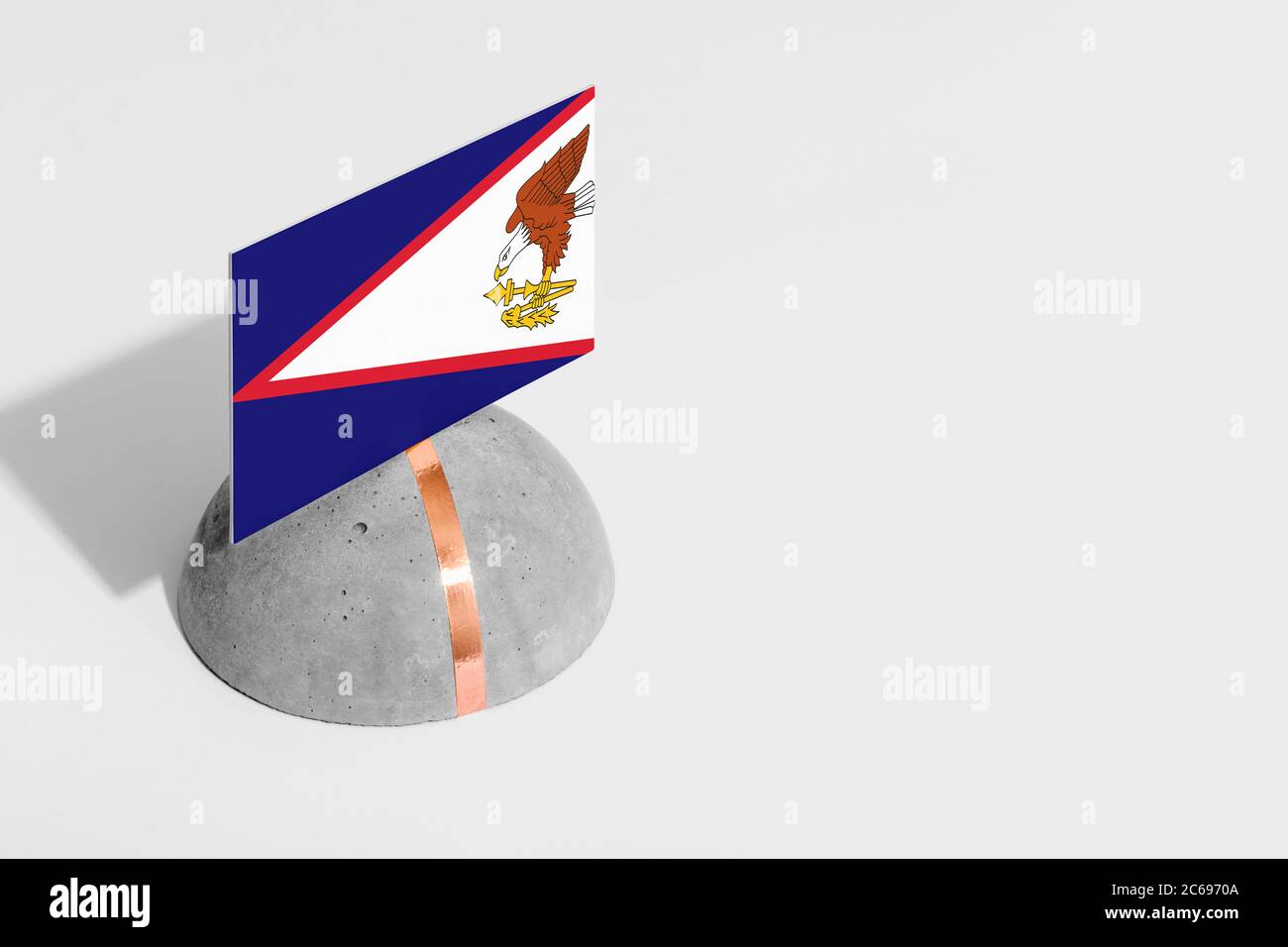 American Samoa flag tagged on rounded stone. White isolated background. Side view minimal national concept. Stock Photo