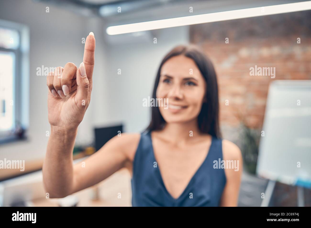 Young woman holding index finger up with great new idea Stock Photo - Alamy