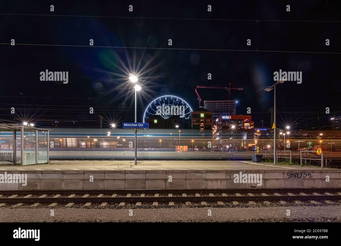 Munich, Germany - 20 of july 2019: View over a empty railway with the hi sky ferris wheel in the background at the station Ostbahnhof in Munich. Stock Photo