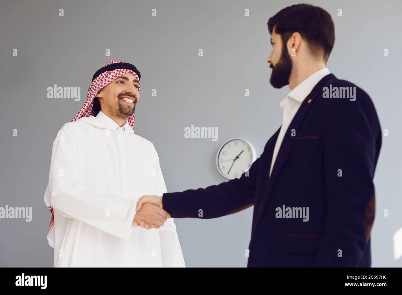 Handshake of arabic and european businesspeople in office. Stock Photo