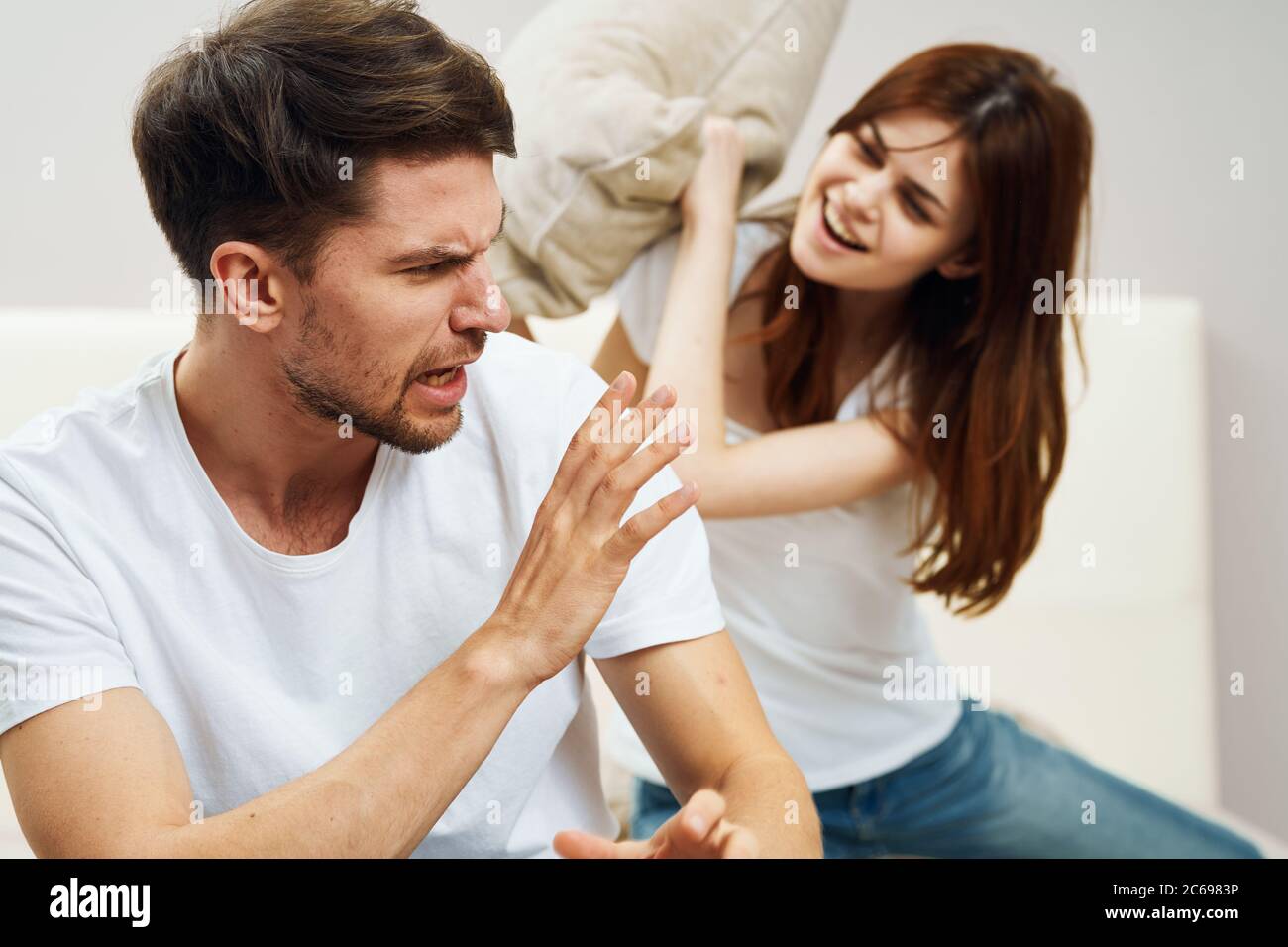 Happy man and woman fight pillows on the bed Stock Photo Alamy