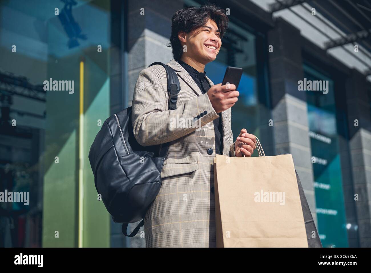 Joyful young man using smartphone on the street Stock Photo