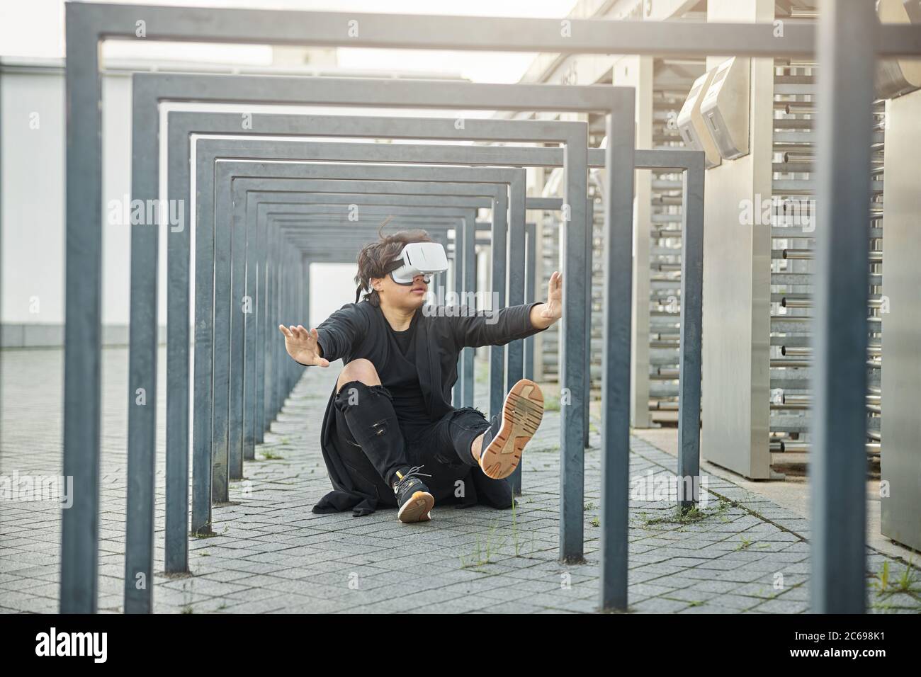 Handsome young man using VR headset outdoors Stock Photo