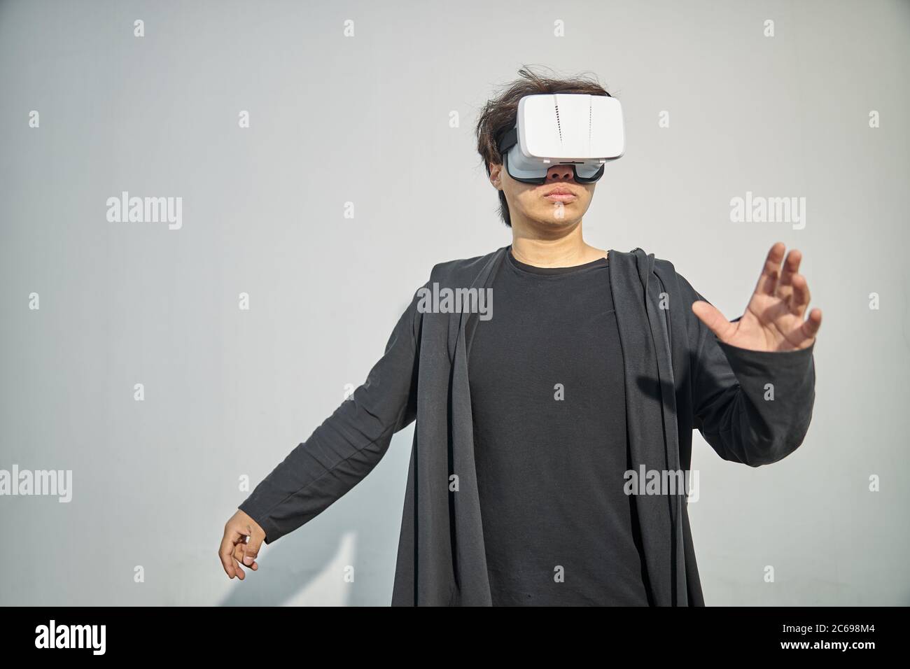 Serious young man wearing virtual reality glasses Stock Photo - Alamy