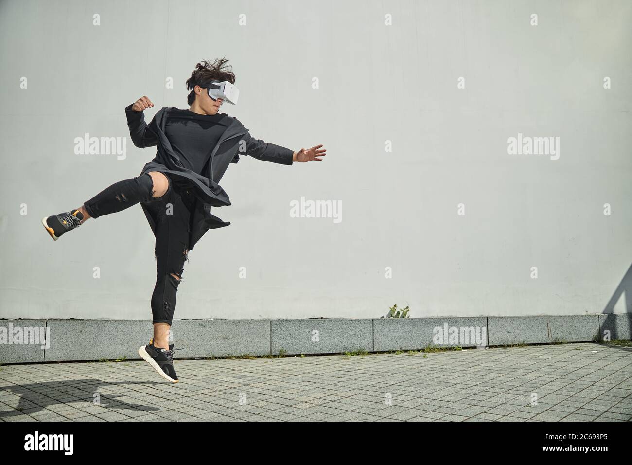 Male fighter using VR headset and jumping in the air Stock Photo - Alamy