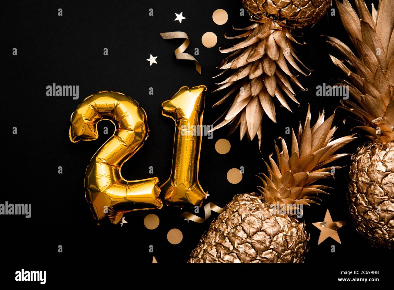 21st birthday celebration background with gold balloons and golden pineapples Stock Photo