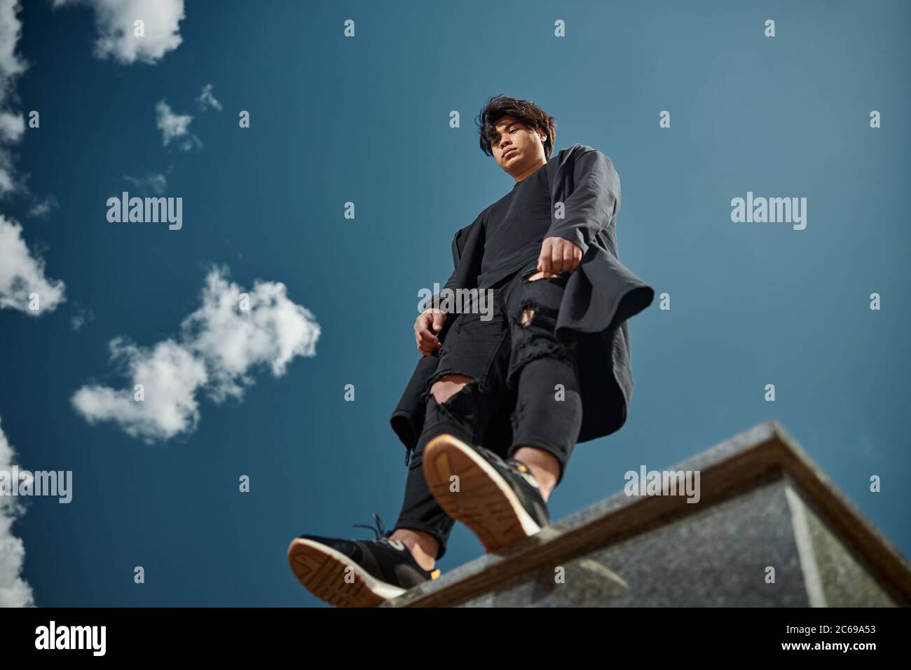 Handsome young man standing under beautiful blue sky Stock Photo - Alamy