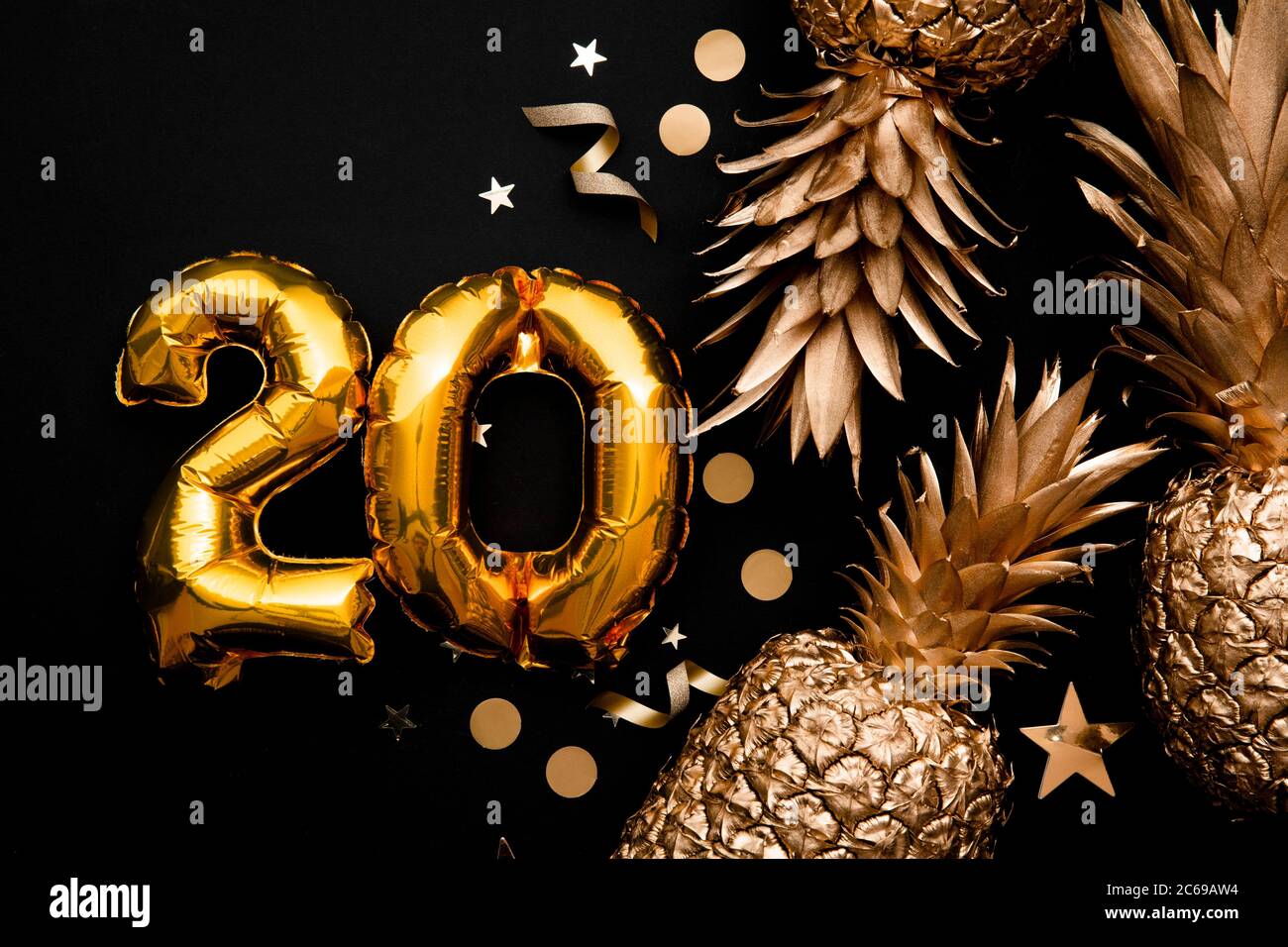 20th birthday celebration background with gold balloons and golden pineapples Stock Photo