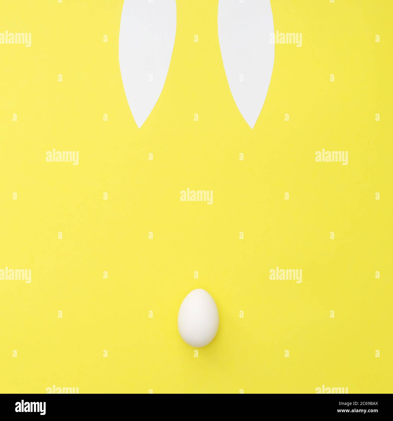 Easter bunny bback view on yellow background. Ears and tail from egg. Minimal easter concept Stock Photo