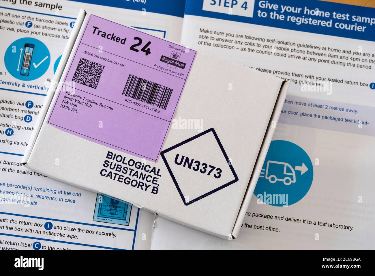 A sealed completed Coronavirus (Covid-19) test in a Biological Substance Category B box on top of instructions for taking a home testing kit, UK Stock Photo