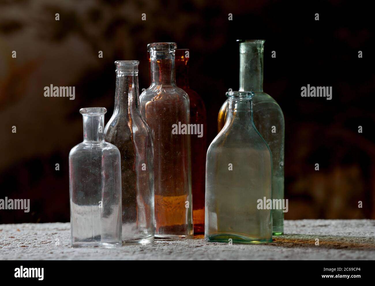 Dusty antique bottles in different colors Stock Photo