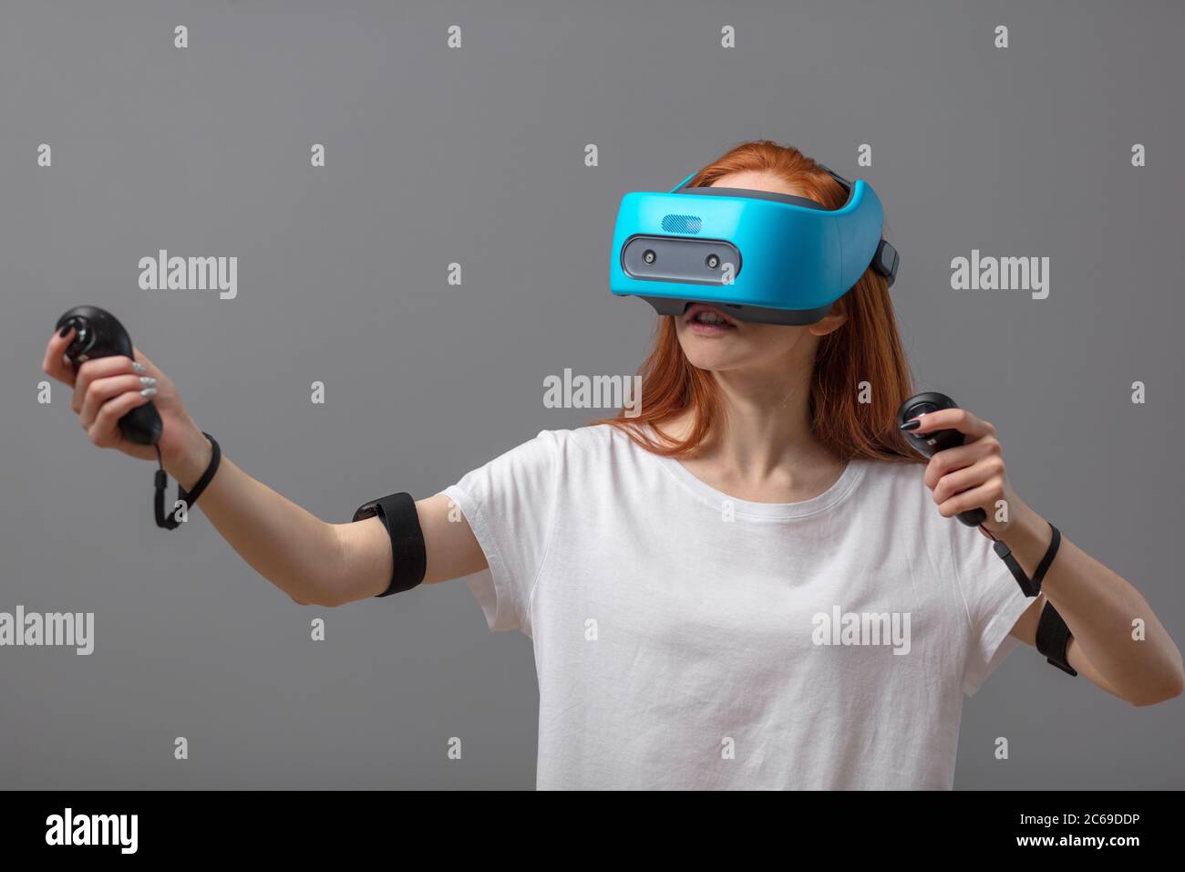 Young woman having fun with new trends innovation technology - Gaming  concept - Isolated studio shot of redhead woman with blue mobile vr headset  Futu Stock Photo - Alamy