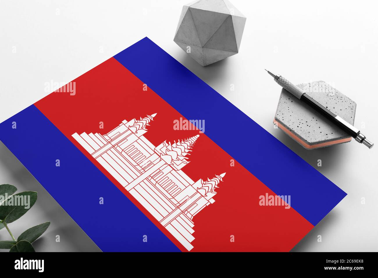 Cambodia flag on minimalist paper background. National invitation letter with stylish pen on stone. Communication concept. Stock Photo