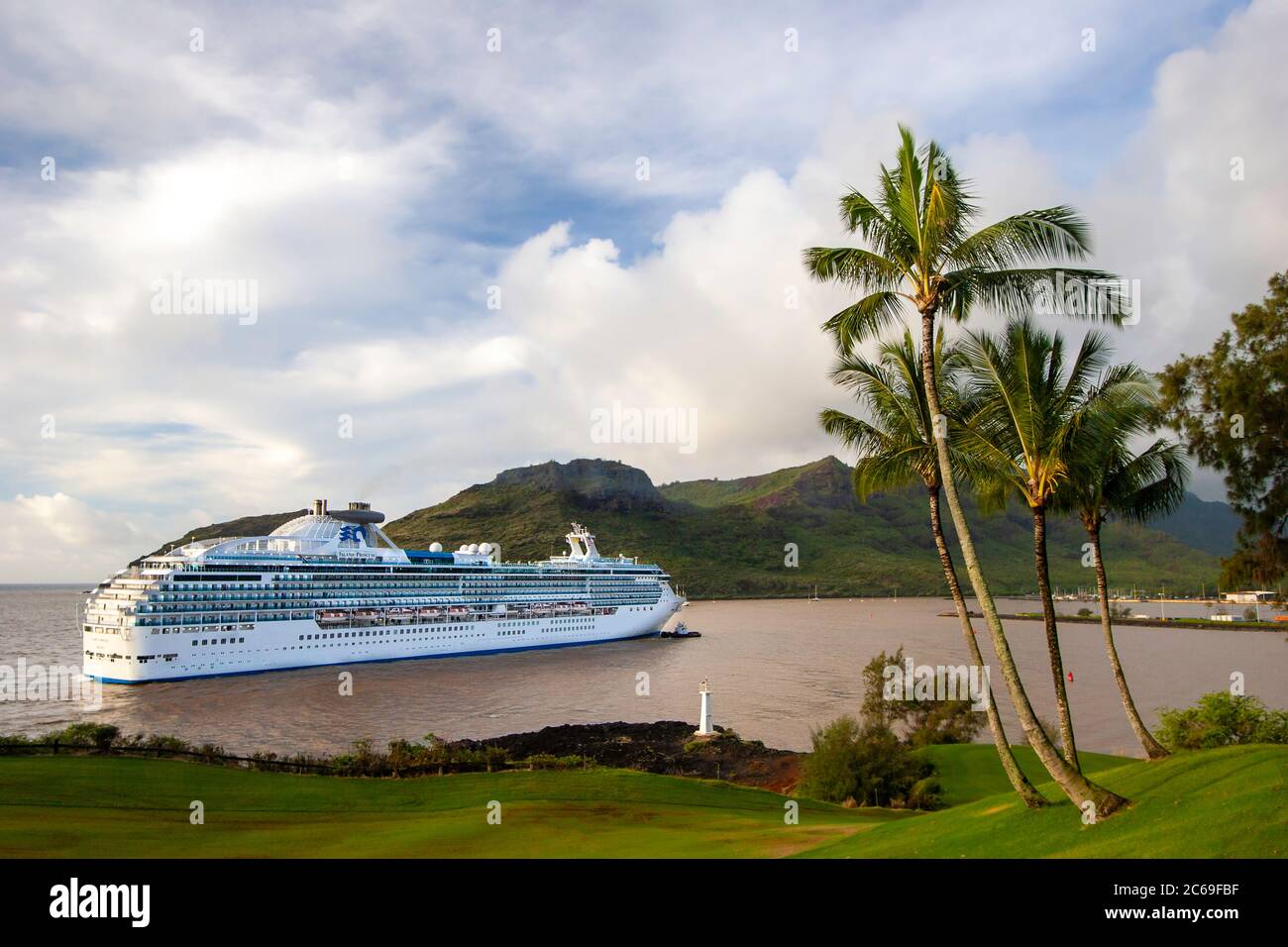 The Island Princess cruise ship gets a tugboat assist pulling into Nawiliwili Small Boat Harbor, Kauai, Hawaii, USA. Nawiliwili Harbor is a cruise shi Stock Photo