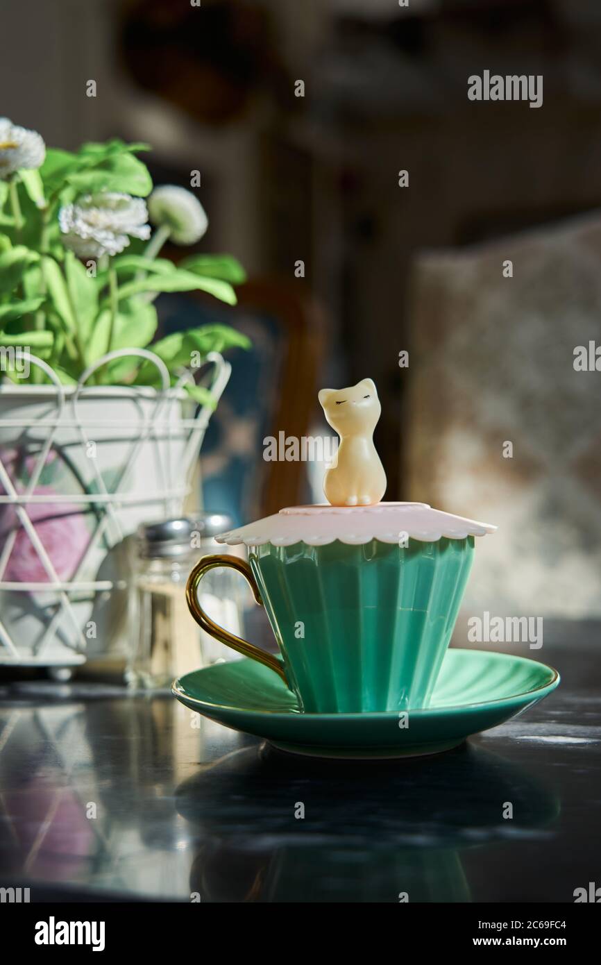A cute figurine cat cup cover in a stylish café in Kuwait. Stock Photo