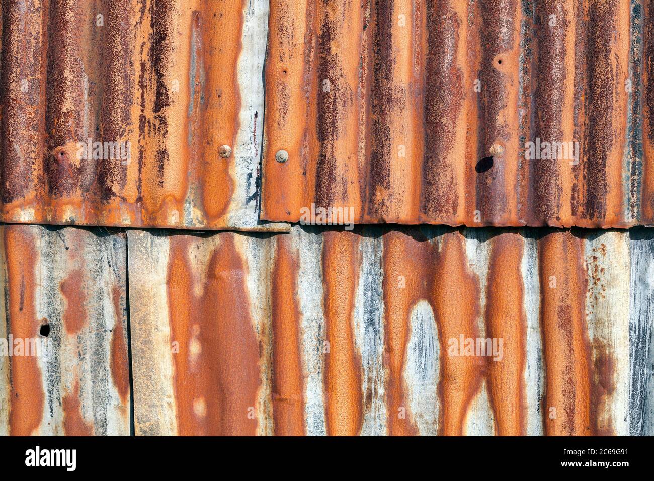 Distressed old corrugated rust covered iron fence texture background Stock Photo