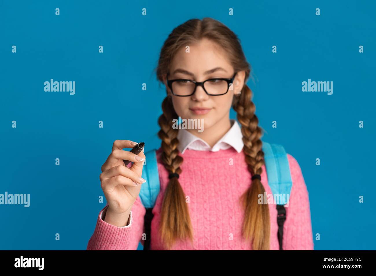 Girl teenager with pigtails and glasses writes with marker on screen Stock  Photo - Alamy