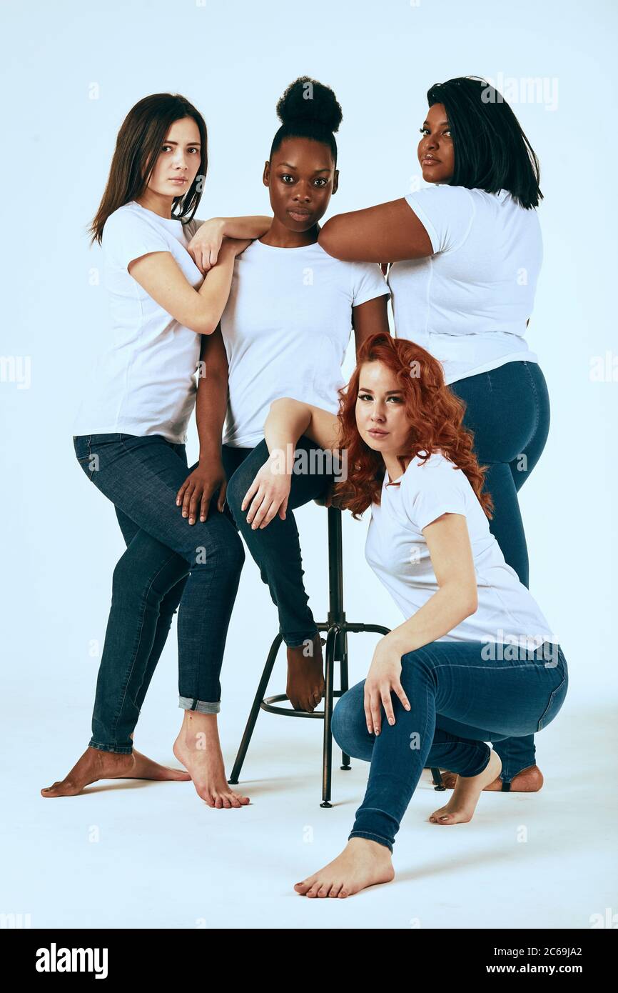 University students posing in studio in skinny jeans and white t-shitrs.  All women are natural and different in their common beauty, having diverse  sk Stock Photo - Alamy
