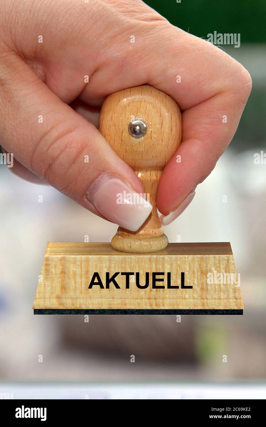 hand with stamp lettering Aktuell; current, Germany Stock Photo