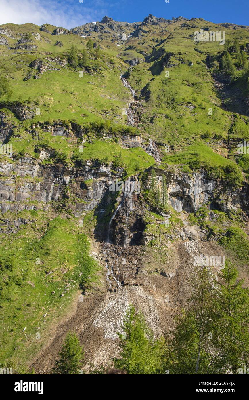 maeltwater draining off und running over the cliff edge to an avalance detritic cone, Austria, Carinthia, Nationalpark Hohe Tauern Stock Photo