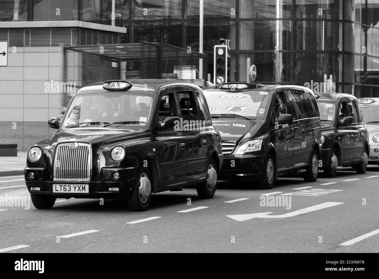 LONDON, UK - 9TH MARCH 2014: A row of Taxis pakred outside some buildings in London during the day Stock Photo