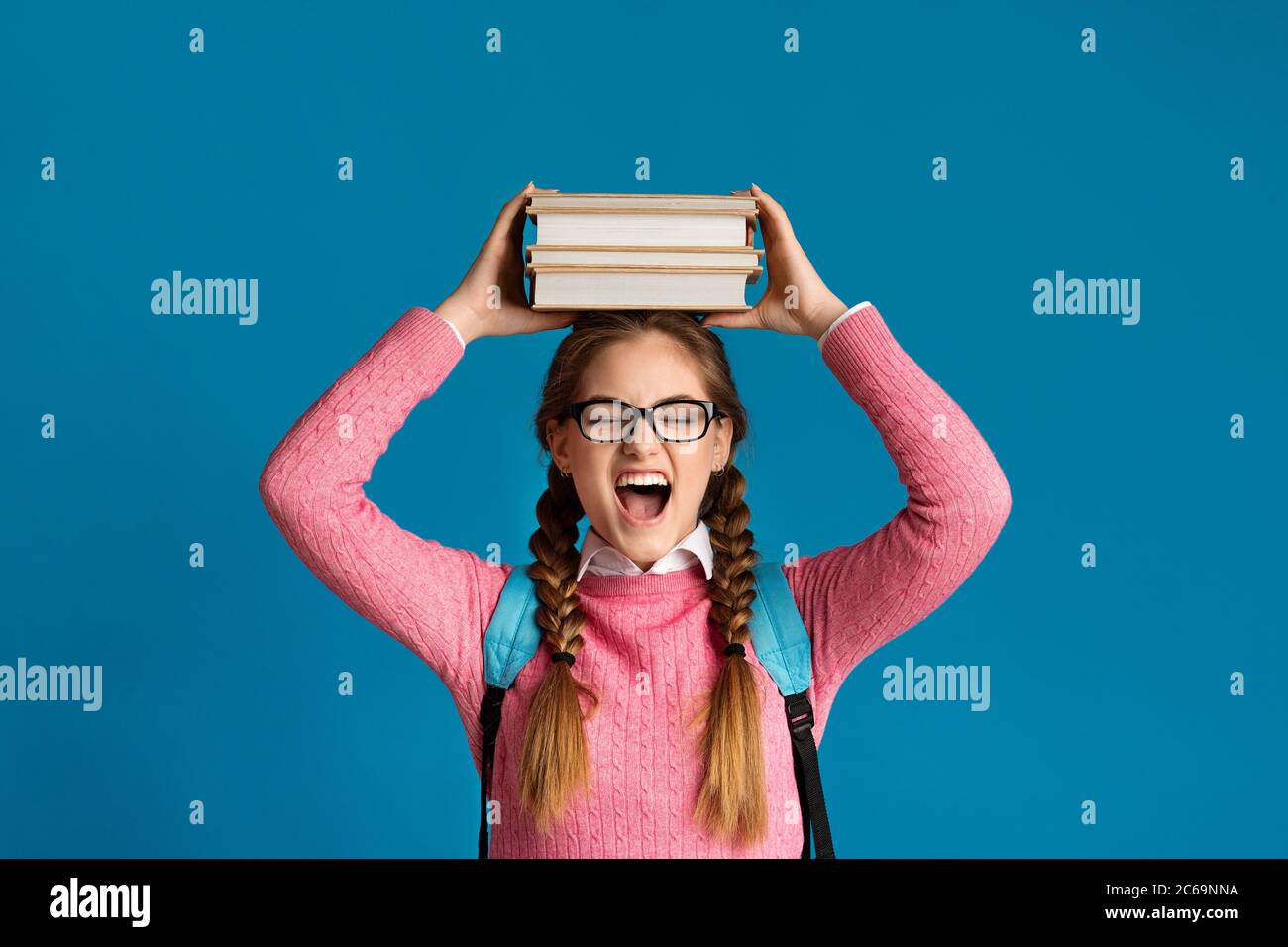Funny teenager girl holds books on head Stock Photo - Alamy