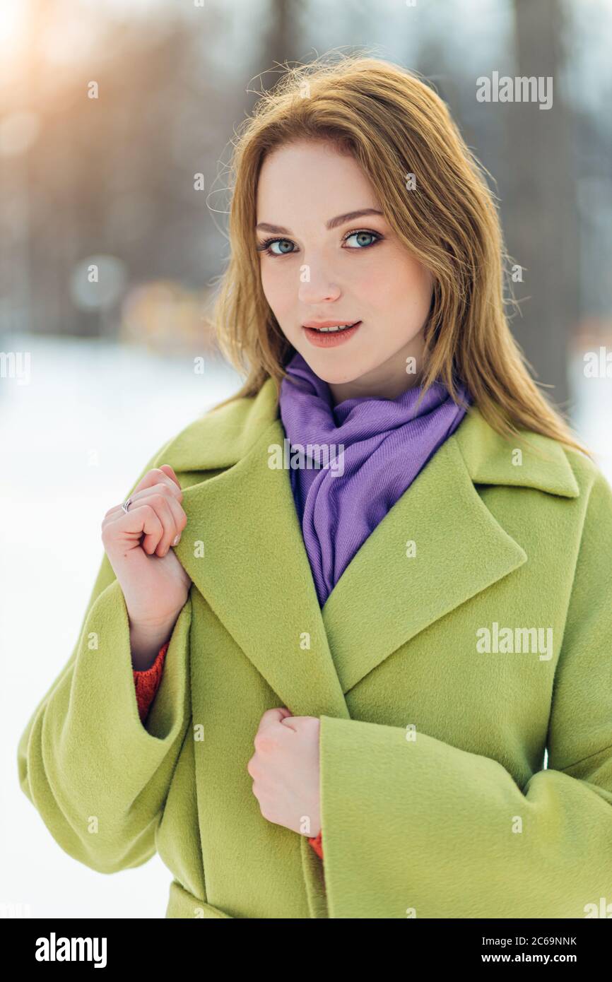 portrait of elegant beautiful caucasian woman in green coat and purple