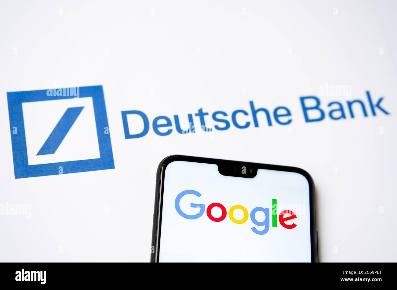 Deutsche Bank logo on printed document and mobile phone with Google logo on the screen. Concept for cooperation of two comp Stock Photo