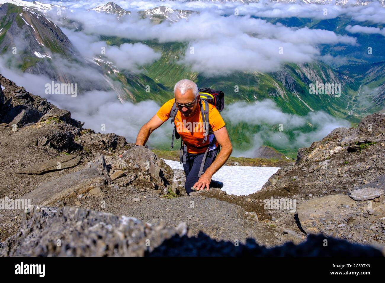 Cheerful man climbing to the summit of the Nufenenstock, Switzerland Stock Photo