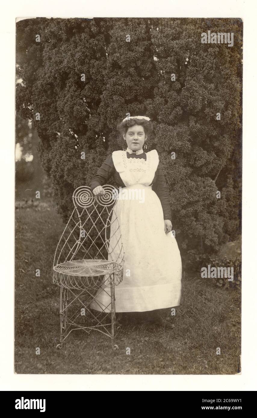 Early 1900's postcard portrait outdoors of maid in garden of a country house, circa 1905, by W. Lee, Abbey Town, Cumbria, England, U.K. Stock Photo