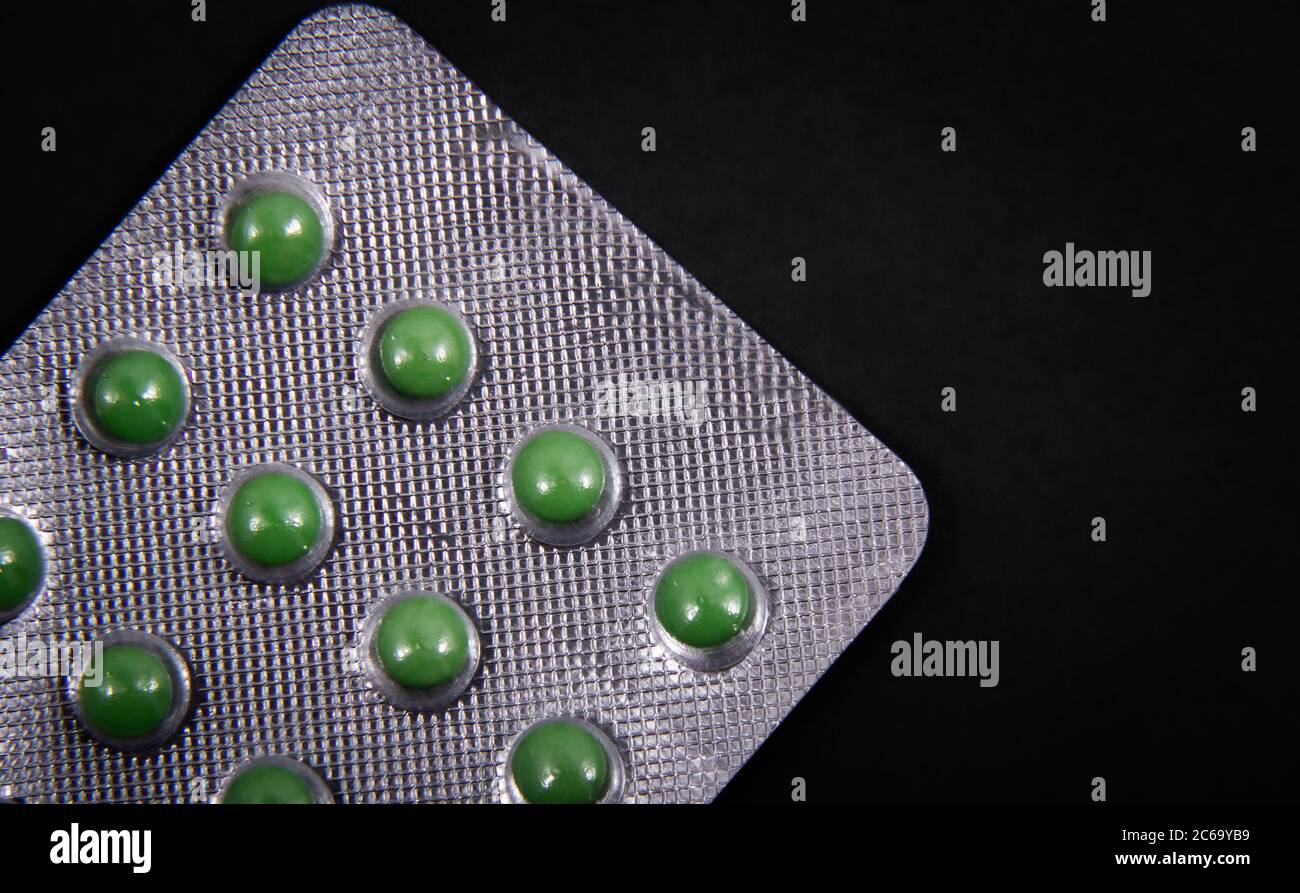 Pills and colored capsules are inside the package. Colored tablets and