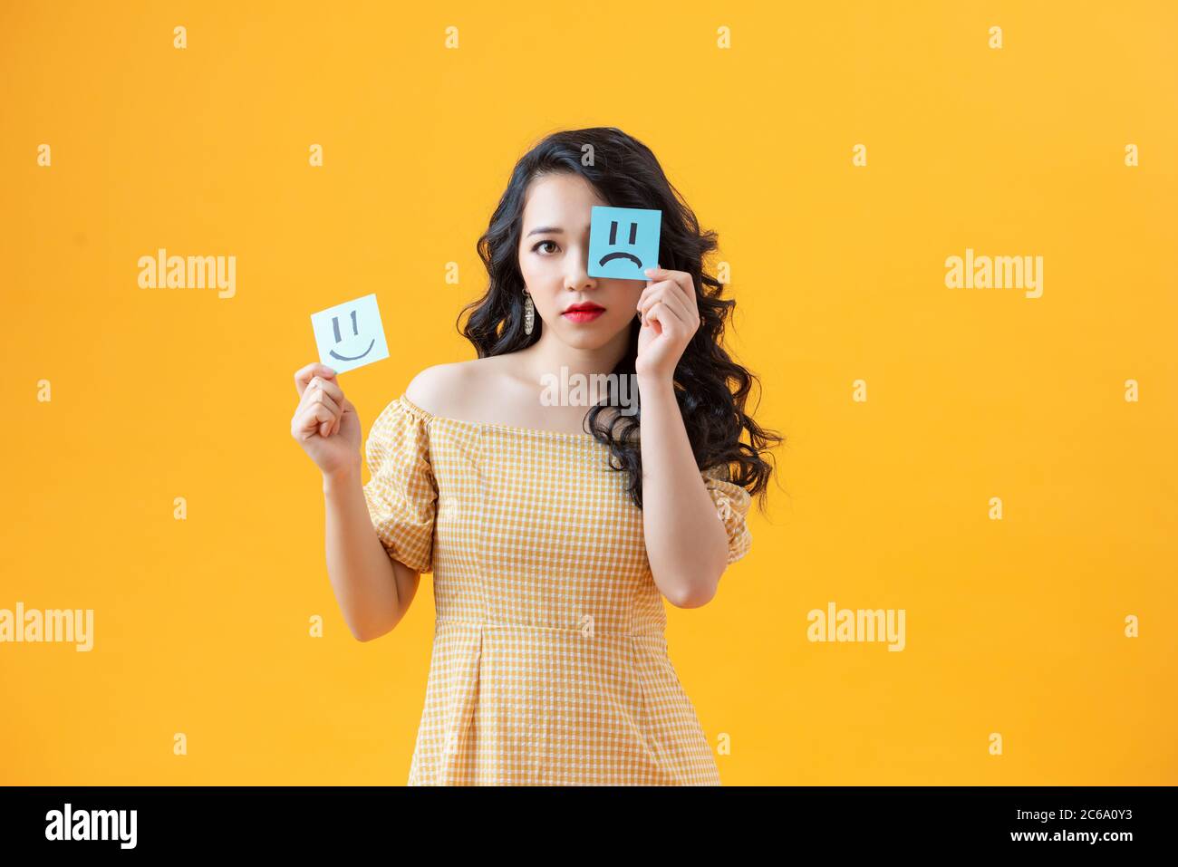 Woman holding notes with painted emoticons, the concept of a good and bad day, mood, work Stock Photo