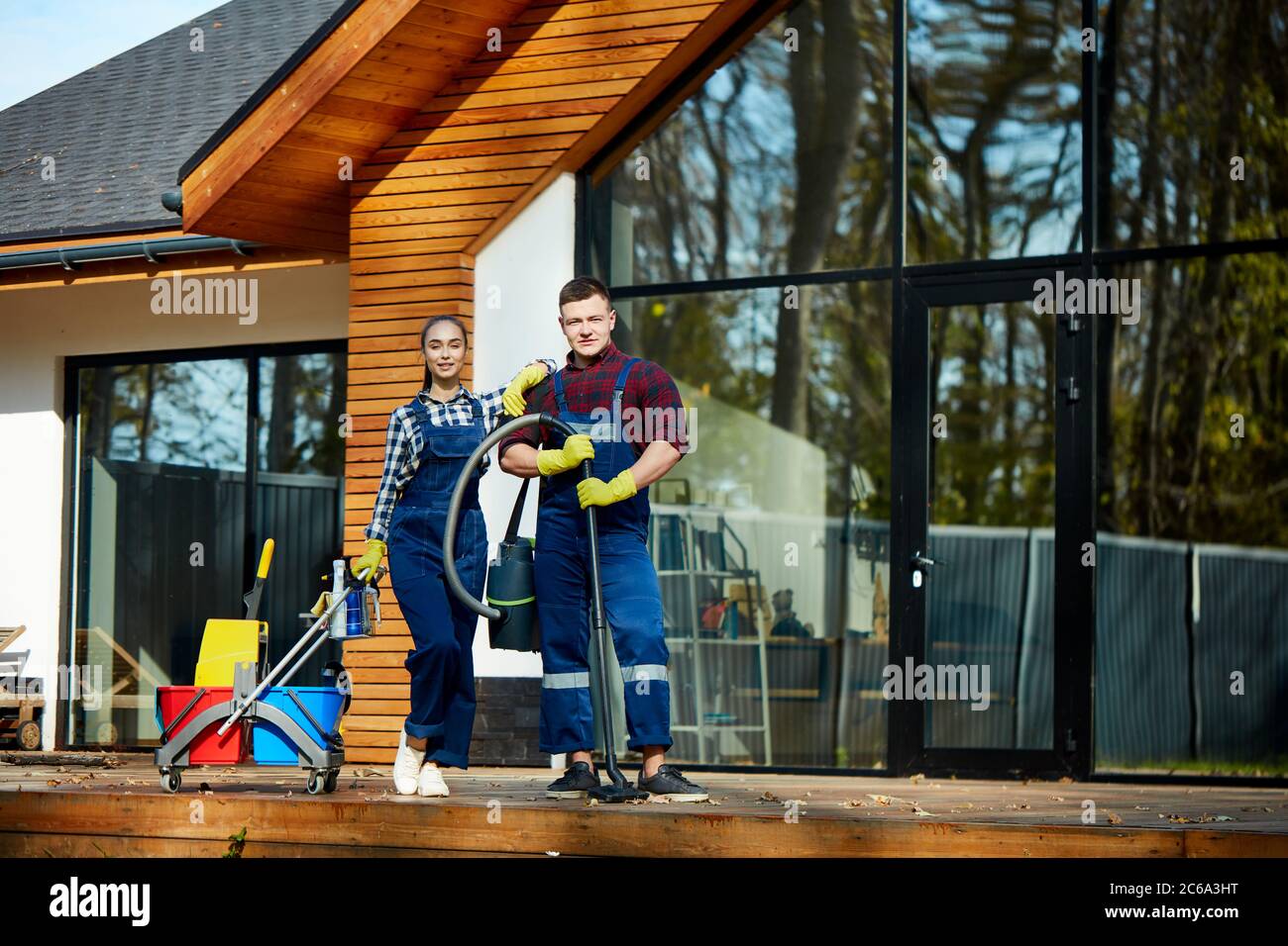 Hardworking cleaners from cleaning service posing holding detergents