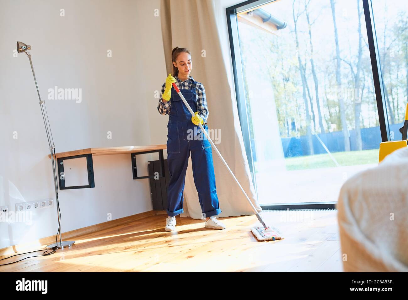 Perfect cleaning service job. Careful janitor in uniform attentively