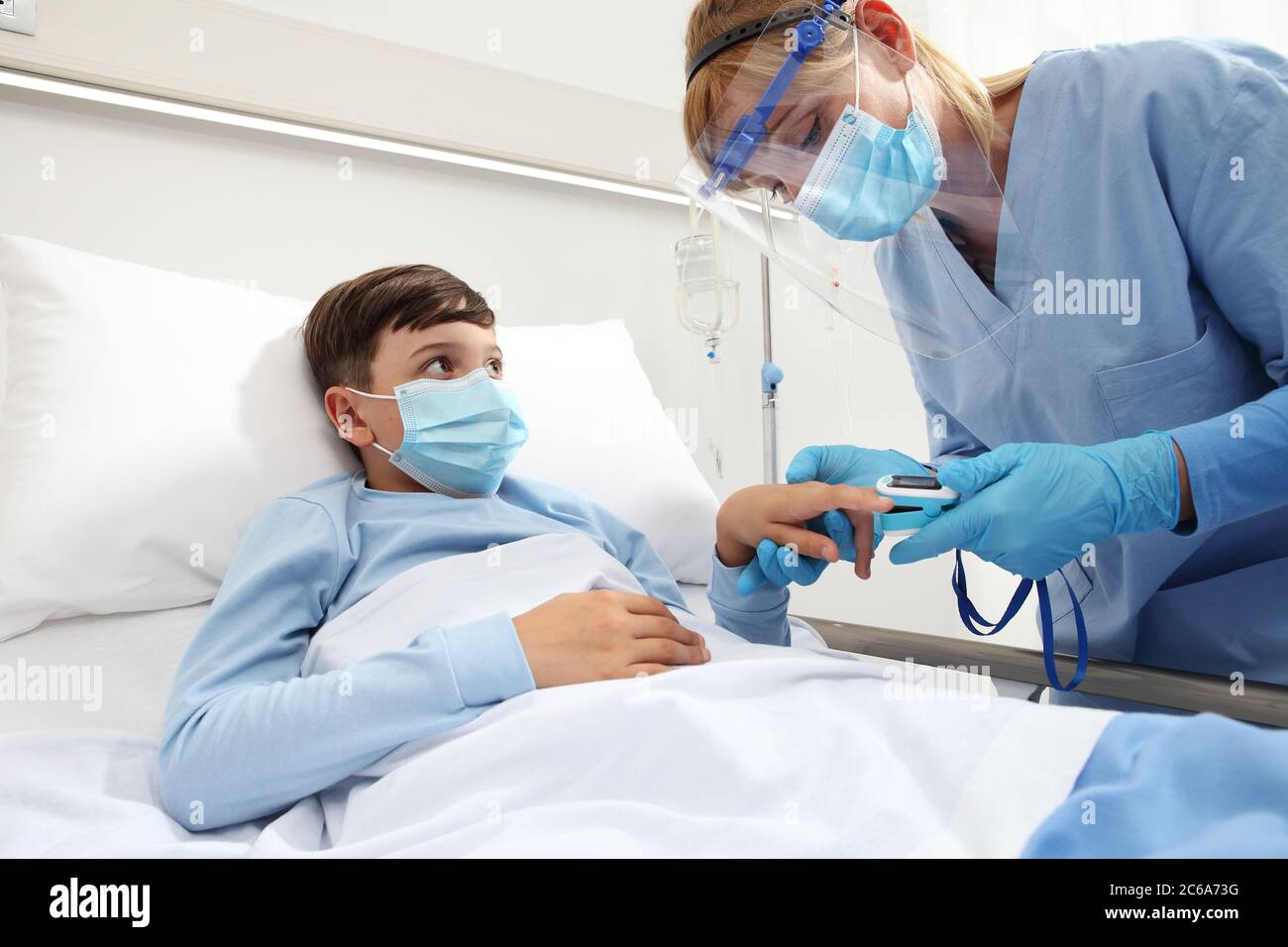 nurse with pulse oximeter on patient child in hospital bed, wearing