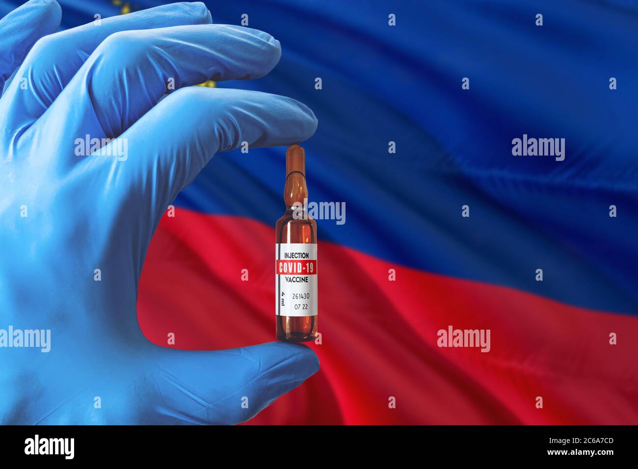 Liechtenstein flag with Coronavirus Covid-19 concept. Doctor with blue protection medical gloves holding a vaccine bottle. Epidemic Virus, Cov-19, Cor Stock Photo