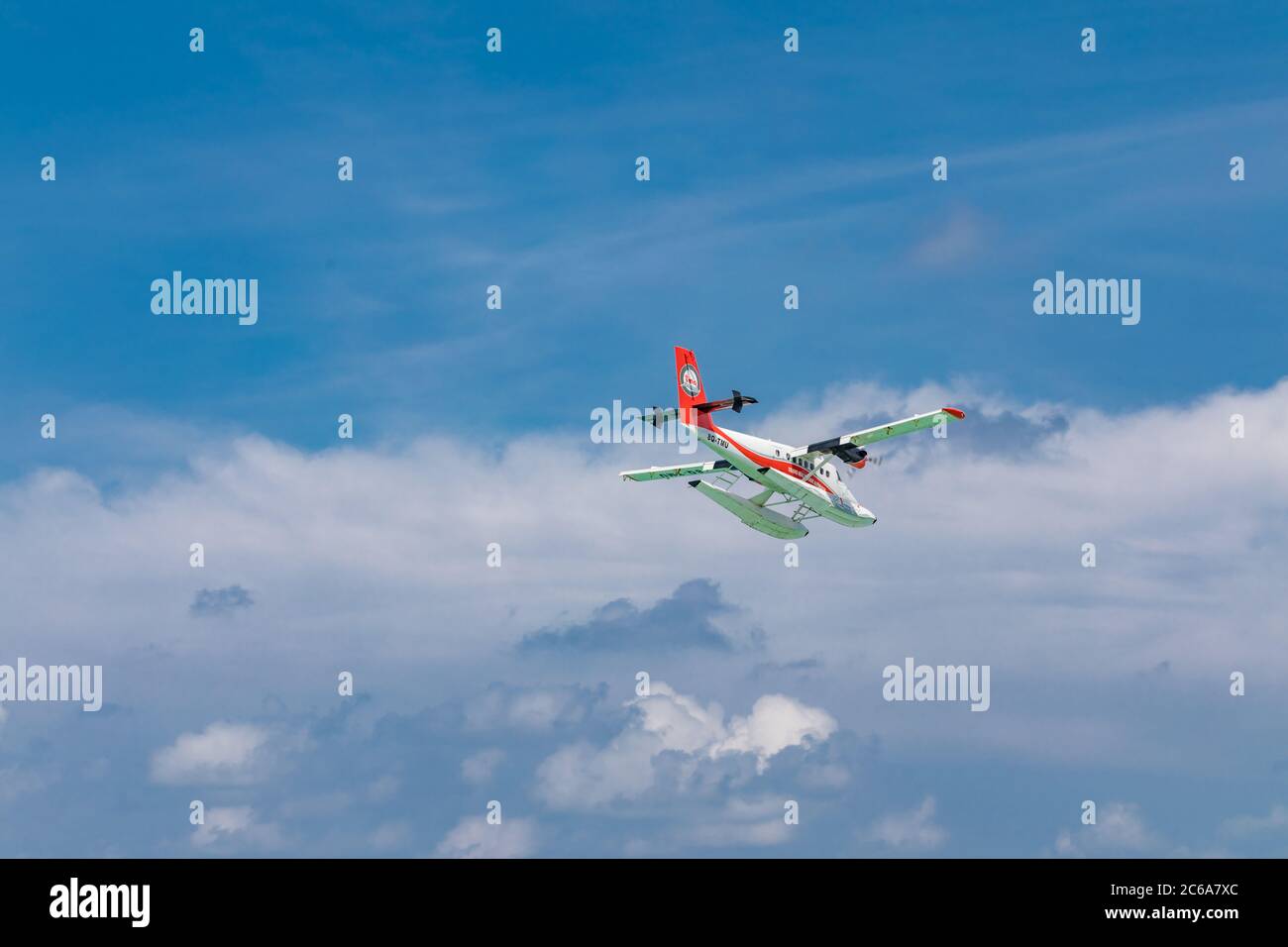 Male, Maldives - 12/17/2017: Seaplane of Trans Maldivian Airways airline is flying in blue sky over Male. Luxury travel, exotic holiday transportation Stock Photo