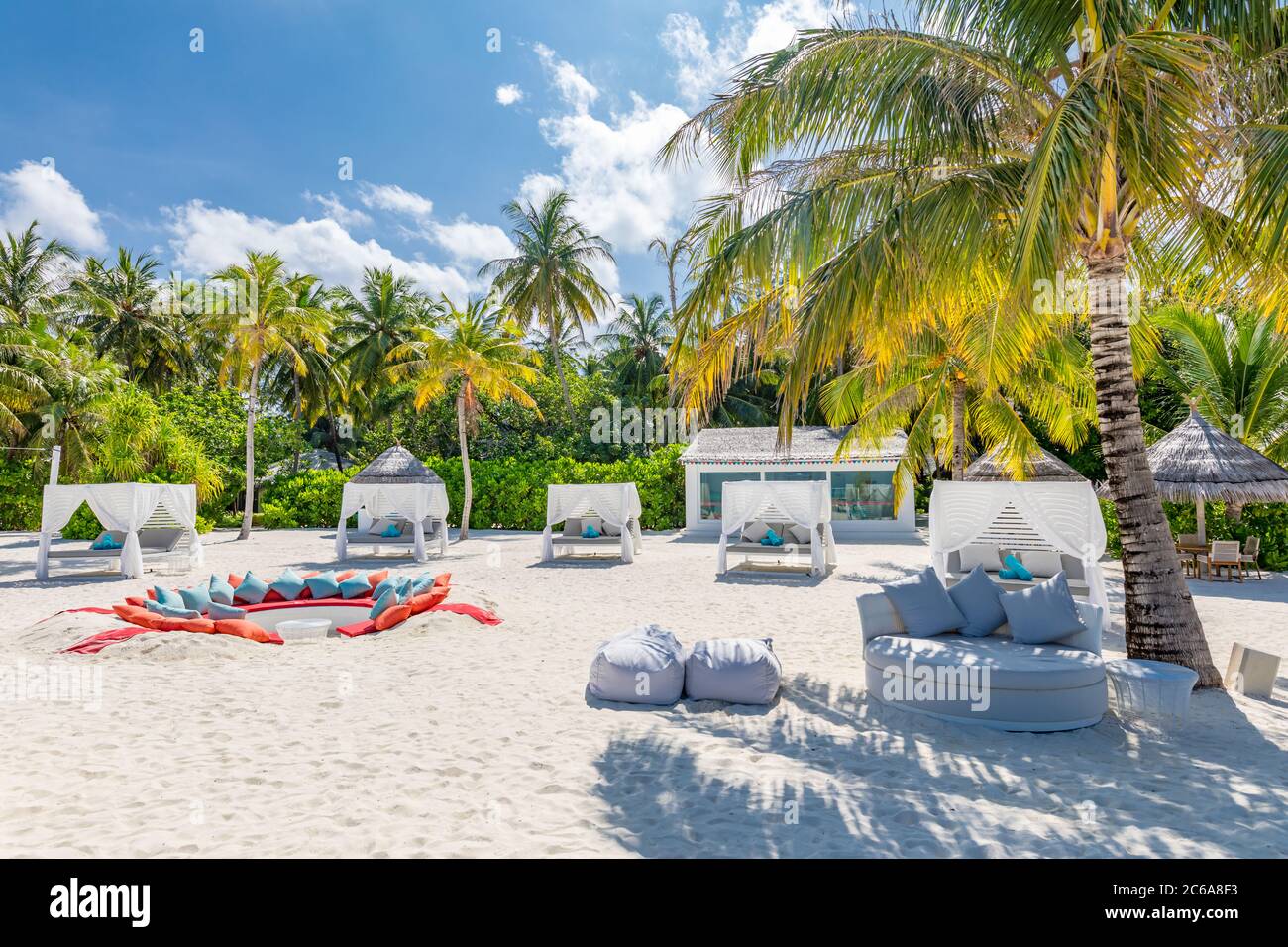 Comfortable chaise with canopy on vip beach seascape. Relaxation zone, tropical resort hotel beach landscape. Palm trees over white sand, vacation Stock Photo