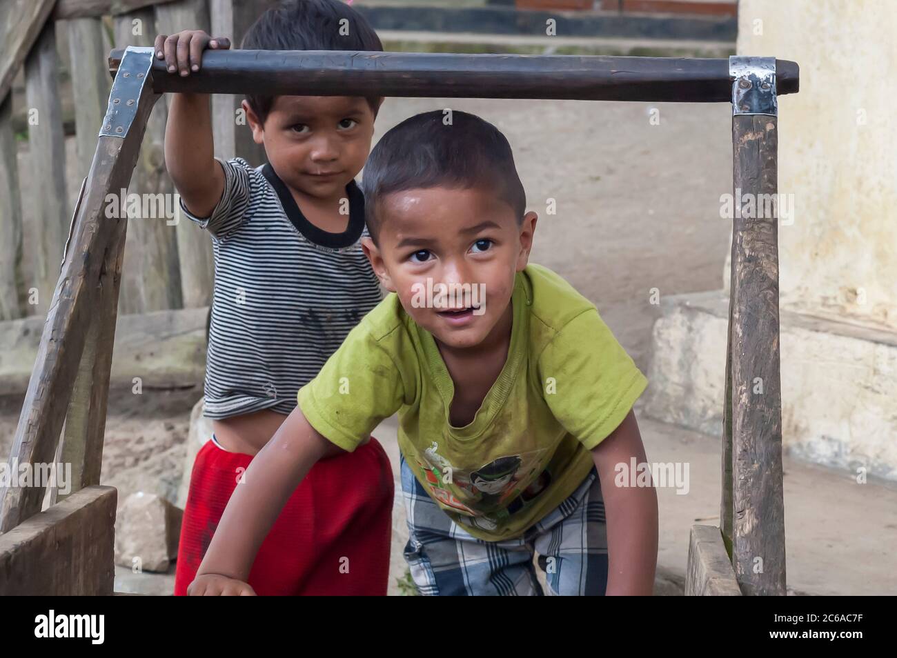 A couple of kids, belonging to the Khasi tribe from Meghalaya, India, playing with a wooden cart outside of their house. Stock Photo