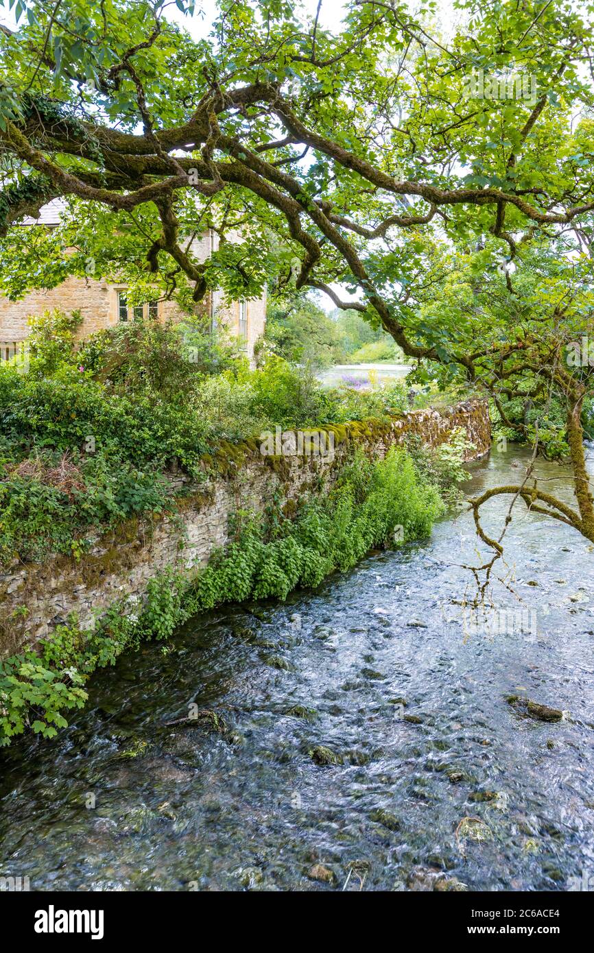 The River Dikler passing by the Old Mill in the Cotswold village of Upper Swell, Gloucestershire UK Stock Photo