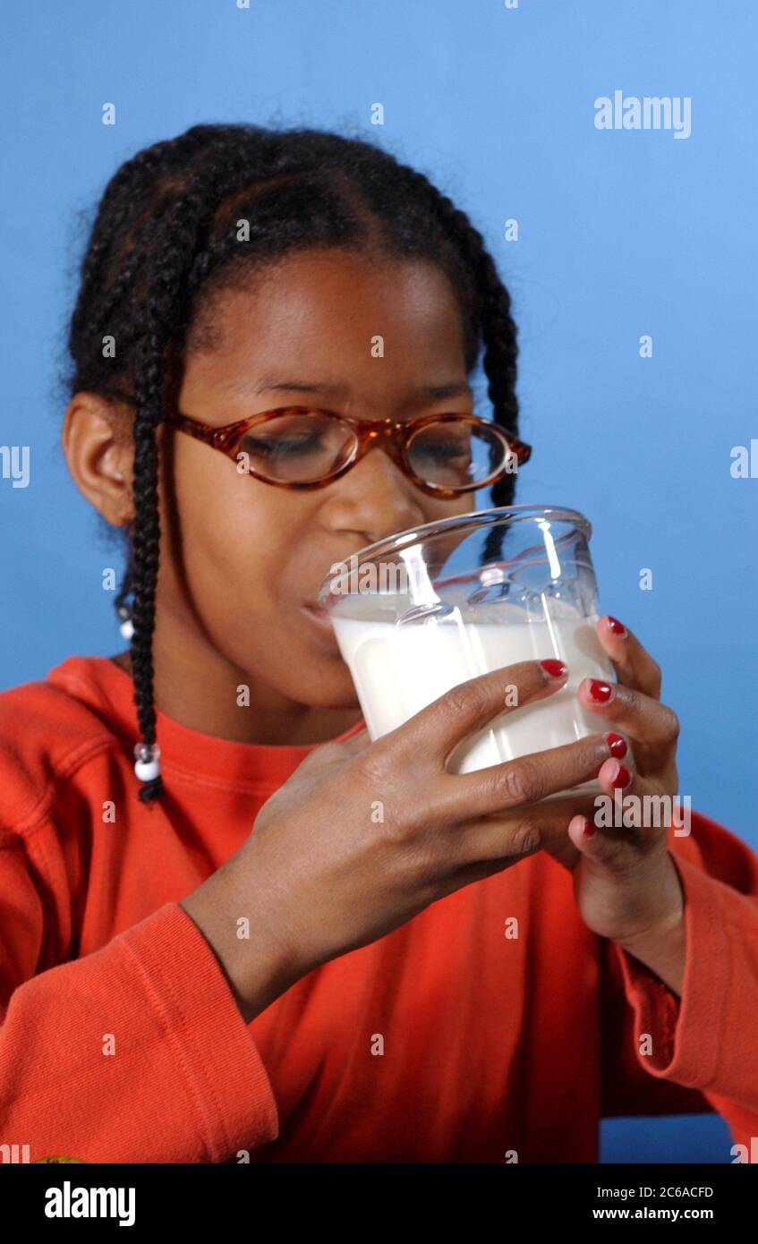 Austin, Texas USA, December 2003: 10-year-old African American girl drinking a glass of milk at home. MR ©Bob Daemmrich Stock Photo