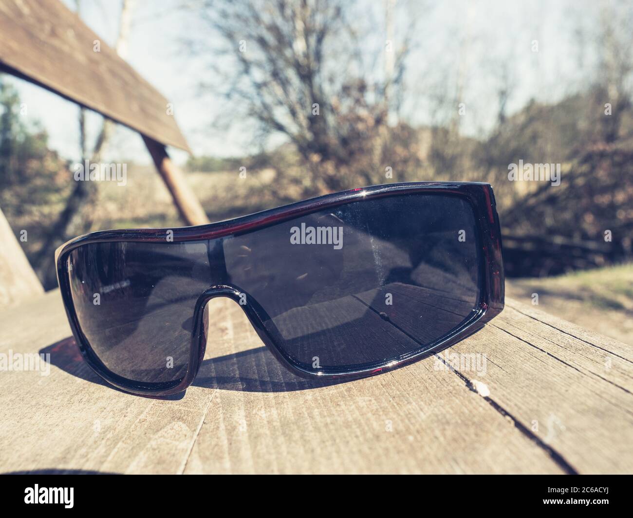 Sunglasses on the Bench on the Nature Background. Reflections in glass  Stock Photo - Alamy