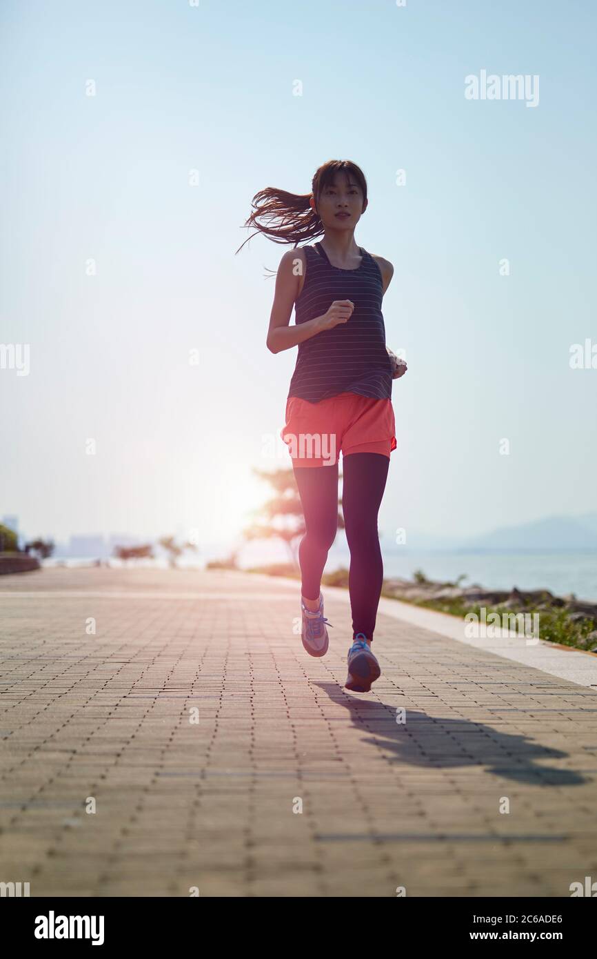 young asian adult woman running jogging outdoors Stock Photo