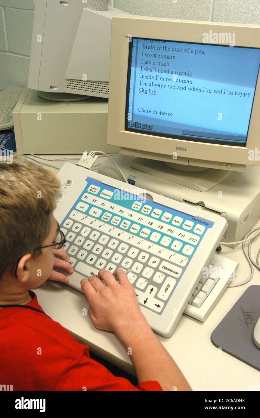 Mabank, Texas USA, September 10, 2003: Twelve-year-old boy with Hurler's Syndrome in writing class in public middle school using Intellikeys augmentative keyboard and CCTV magnifier that helps him read books his computer screen. MODEL RELEASE SP73  ©Bob Daemmrich Stock Photo