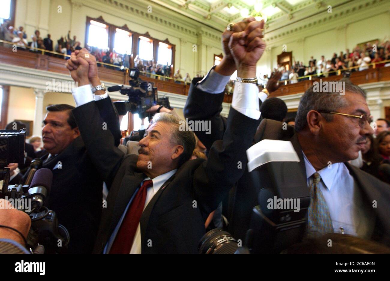 September 15, 2003: Texas' absent Democratic senators, including left to right, Sen. Eddie Lucio, Sen. Gonzalo Barrientos and Sen. Mario Gallegos,  who spent more than six weeks in exile in New Mexico, return Monday to the State Capitol to the rousing cheers of a Senate gallery packed with Democratic supporters.  Senate decorum was non-existent as legislators, media and spectators swarmed the chamber in a historic moment for Texas.  ©Bob Daemmrich Stock Photo