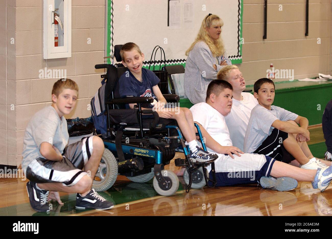 Mabank, Texas USA, September 10, 2003: 12-year-old boy with cerebral palsy and learning disability waits on sidelines with teammates during gym class, mainstreamed with other children. MODEL RELEASE SP-71 (boy in wheelchair). Others not released.  ©Bob Daemmrich Stock Photo