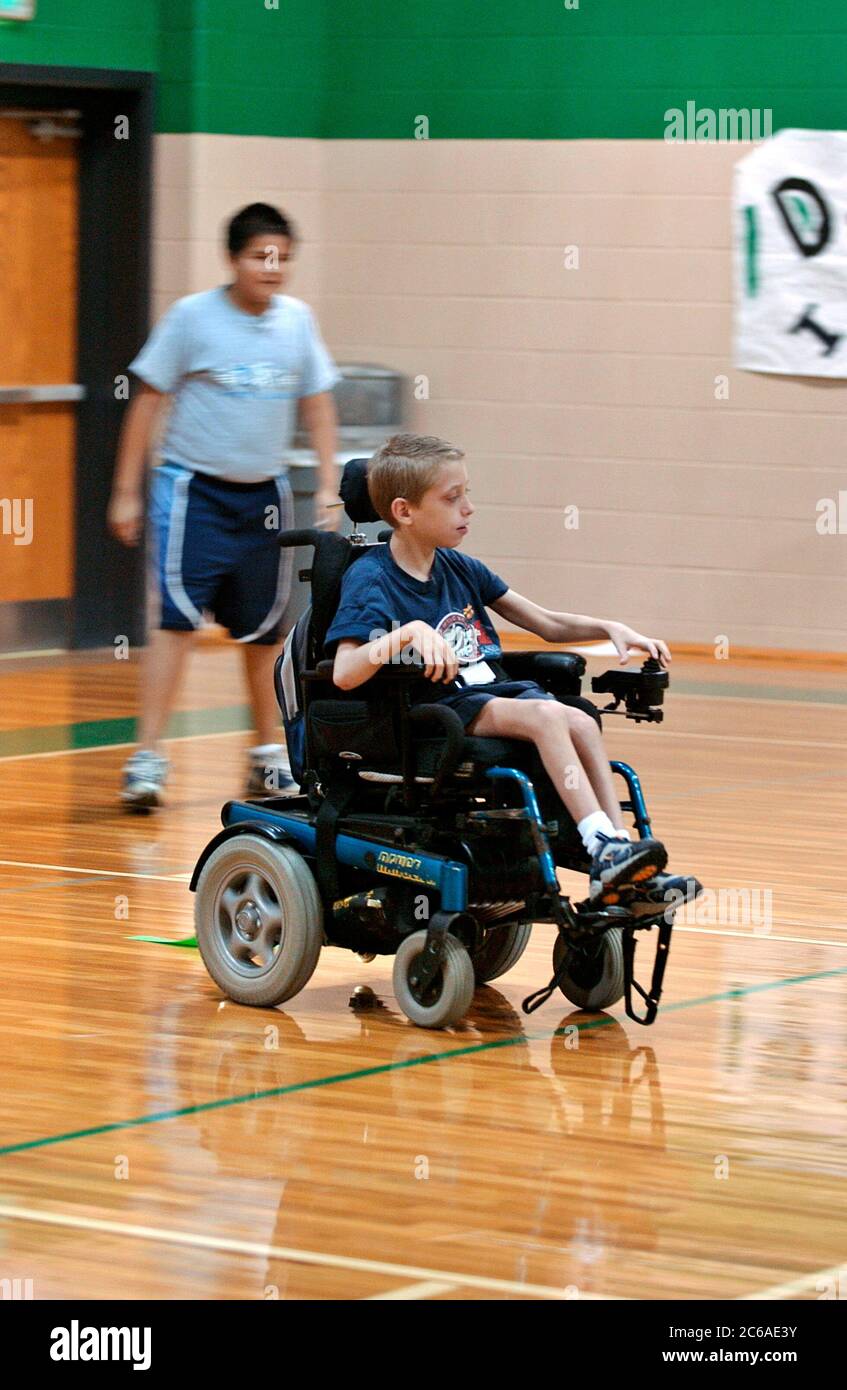 Mabank, Texas USA, September 10, 2003: 12-year-old boy with cerebral palsy and learning disability plays 'flag tag' in gym class, mainstreamed with other children. MODEL RELEASE SP-71 (boy in wheelchair). Others not released.  ©Bob Daemmrich Stock Photo