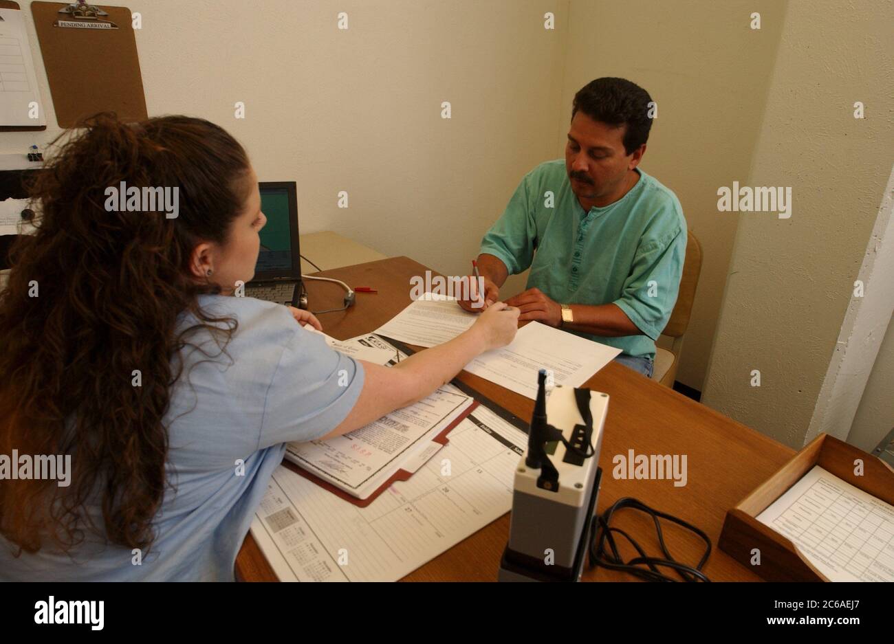 Parole Officer signing up a parolee for electronic monitoring via Global Positioning System (GPS) monitoring. Models Released ©Bob Daemmrich Stock Photo