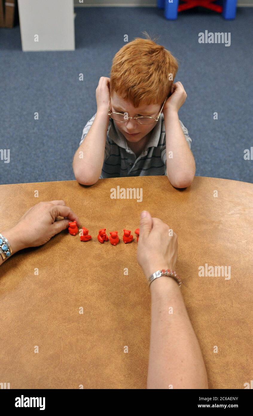 Mabank, Texas USA, September 10, 2003: Developmentally delayed boy with fetal alcohol syndrome learning to count in pairs in special education class at his elementary school.  ©Bob Daemmrich Stock Photo