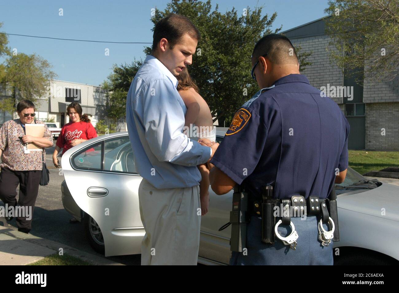 San Antonio, Texas August 7-8, 2003: Officer Ben Sigala assists Children's Protective Services (CPS) with the removal of a baby and mother from a home. No Releases available. ©Bob Daemmrich Stock Photo